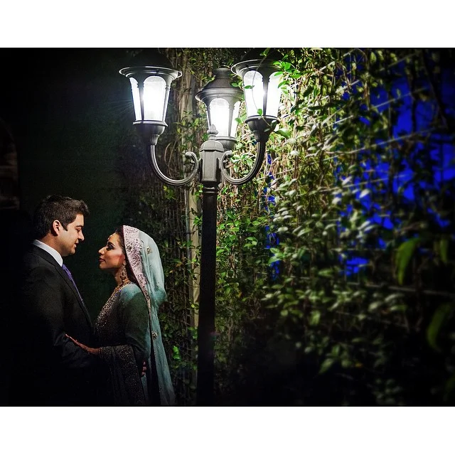 Couple embracing under the lamp in the Waterwall garden bar area at The Bell Tower on 34th, Houston, TX.